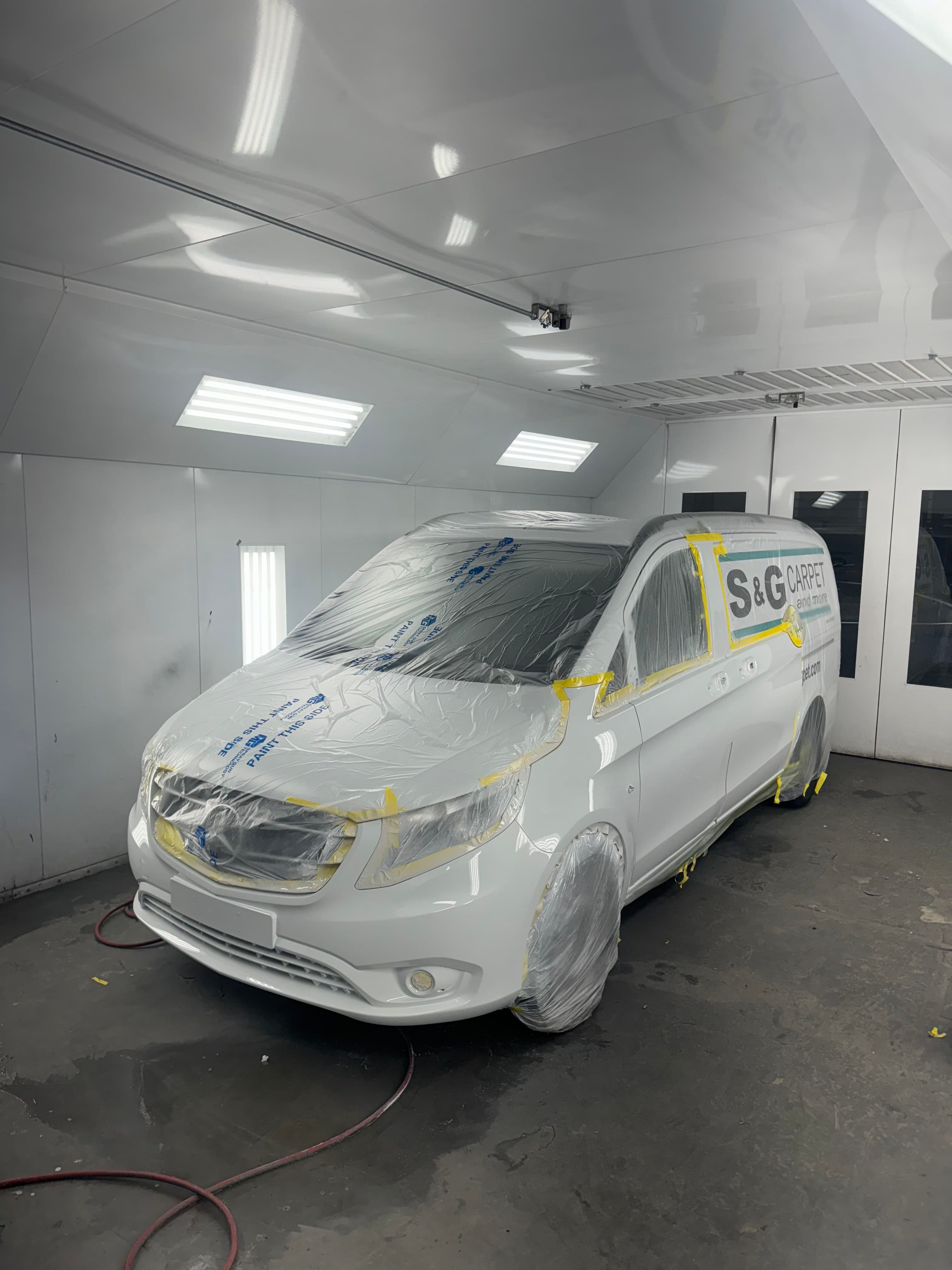 White Mercedes-Benz commercial van masked for paint in the spray booth at D&S Auto Repair in Vallejo, CA