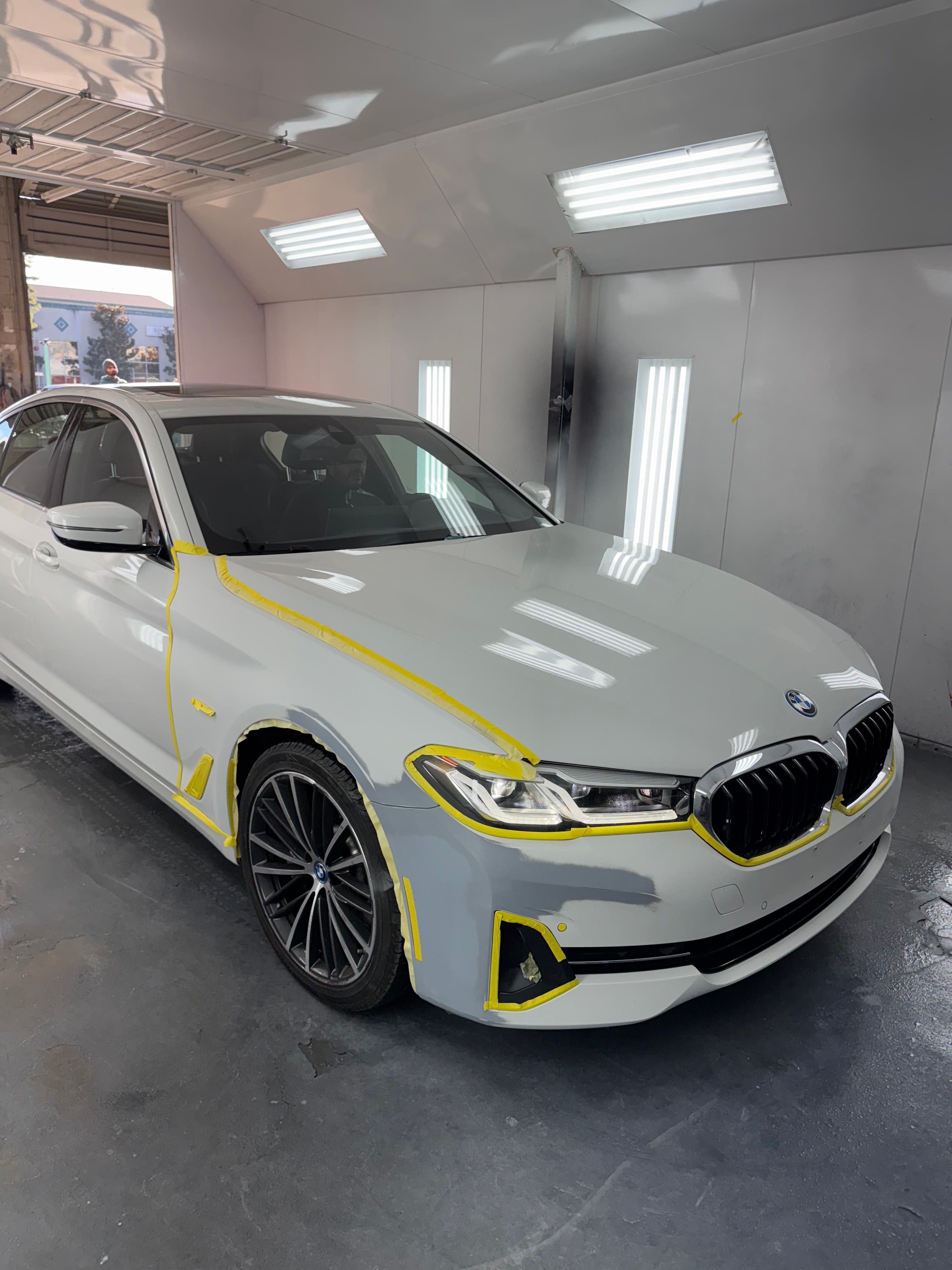 White BMW 5 Series masked for front bumper and fender paint at D&S Auto Repair in Vallejo, CA